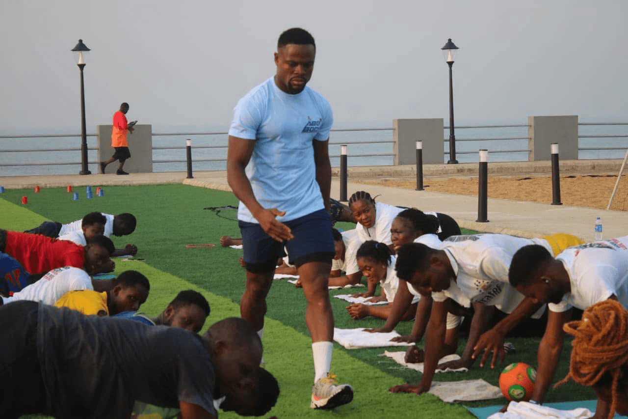Abel Gebor coaching a large outdoor group fitness session